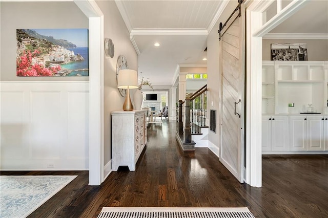 corridor with crown molding, dark wood-style flooring, a barn door, recessed lighting, and stairway