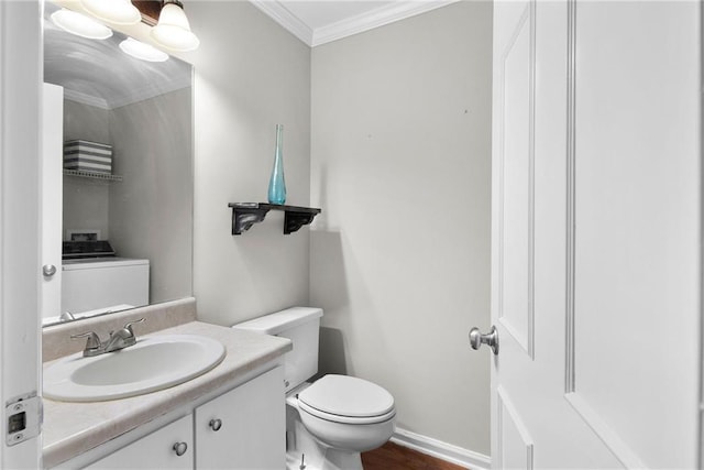 bathroom featuring washer / clothes dryer, toilet, ornamental molding, vanity, and baseboards