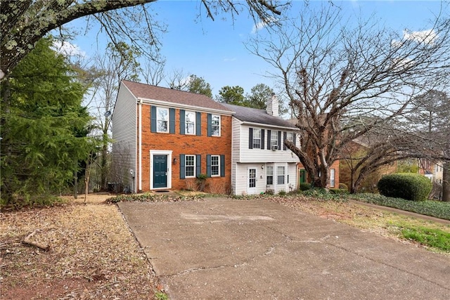 view of front facade featuring a chimney and brick siding