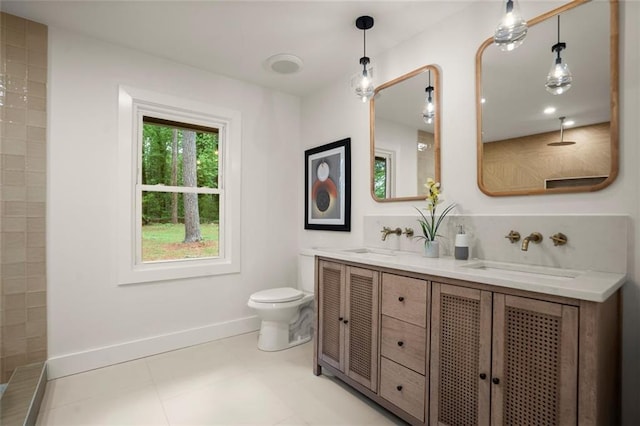 full bathroom with toilet, double vanity, a sink, and baseboards