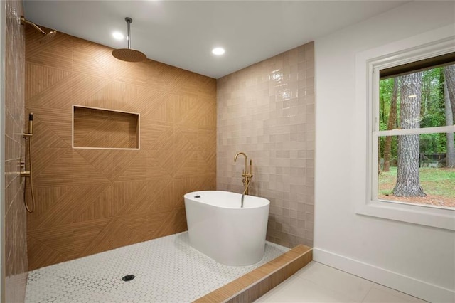 bathroom with recessed lighting, tile walls, a freestanding bath, tile patterned flooring, and tiled shower