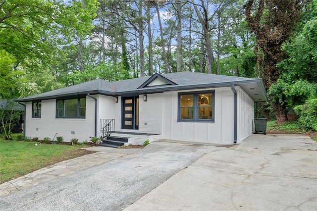 ranch-style house featuring brick siding, a shingled roof, and driveway
