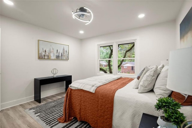 bedroom with light wood-type flooring, recessed lighting, and baseboards