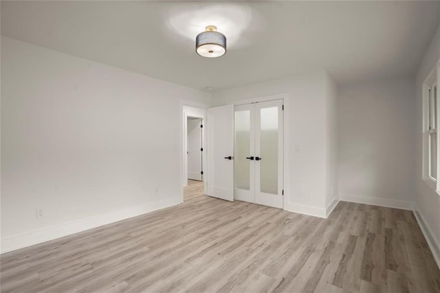 unfurnished room with light wood-style flooring and baseboards
