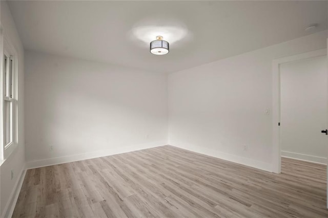 empty room with baseboards and wood finished floors