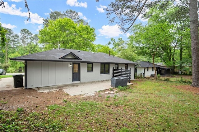 rear view of property featuring fence, board and batten siding, cooling unit, and a patio area