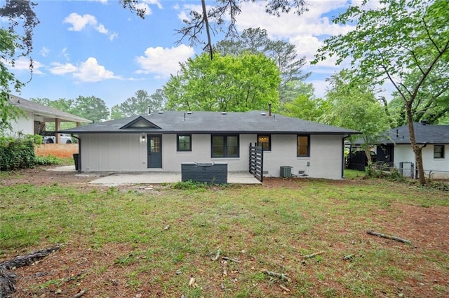 rear view of property with a patio, fence, central AC unit, and a yard