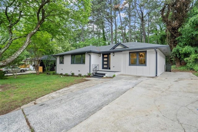 view of front of house with a front lawn, driveway, and board and batten siding