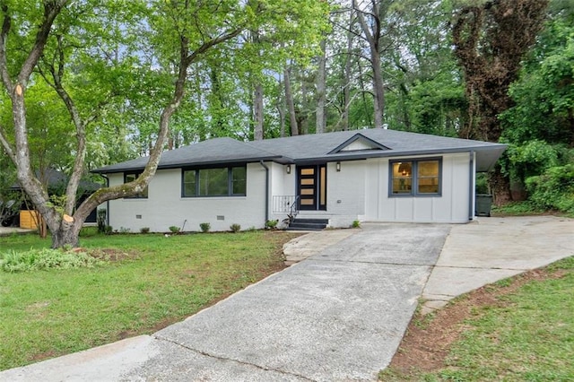 single story home with a front lawn, a shingled roof, board and batten siding, brick siding, and concrete driveway