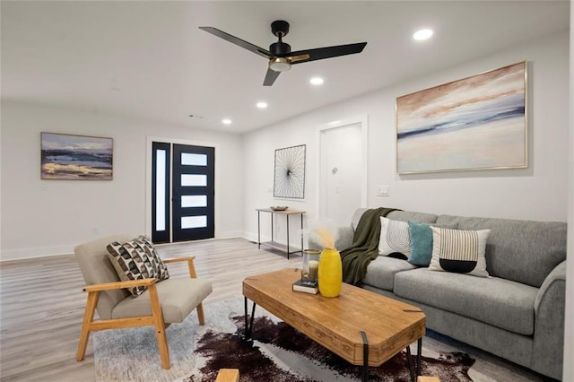 living room with recessed lighting, a ceiling fan, baseboards, and light wood-type flooring