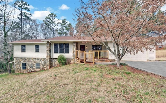 ranch-style house with a garage, covered porch, driveway, and a front lawn