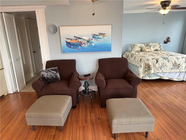 bedroom featuring wood finished floors, a ceiling fan, and crown molding