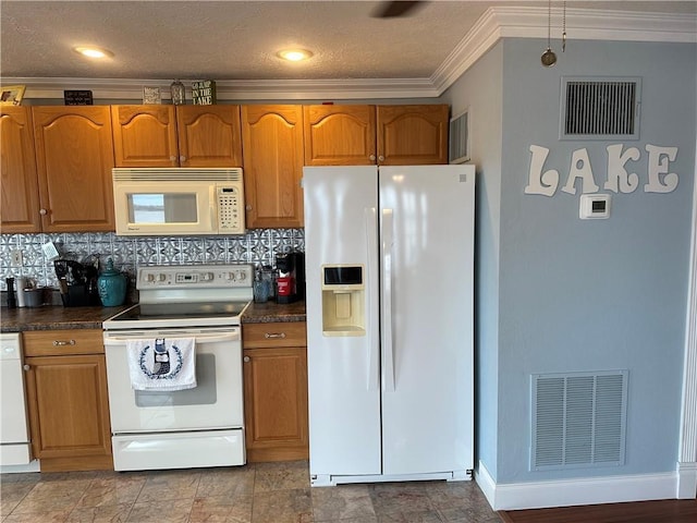 kitchen with dark countertops, white appliances, and visible vents