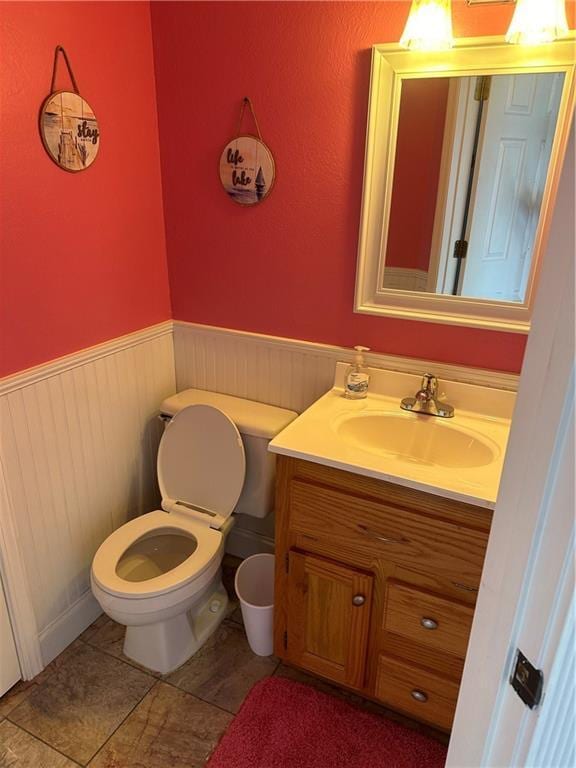 bathroom featuring a wainscoted wall, vanity, and toilet