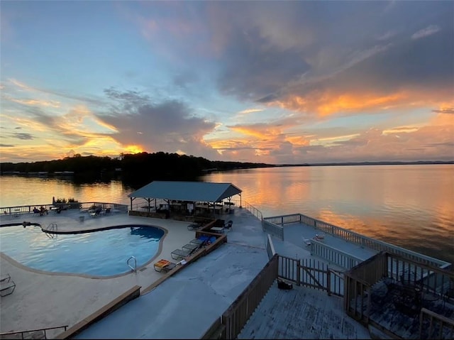 dock area with a water view and an outdoor pool