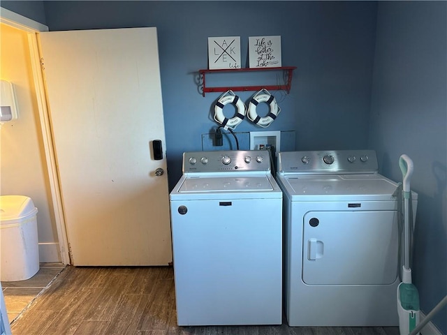 laundry area with laundry area, wood finished floors, and washing machine and dryer