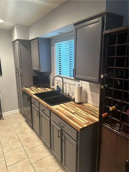 102 Cedar Chase Rd, Atlanta, GA 30324 - kitchen with sink, black dishwasher, gray cabinets, decorative backsplash, and light tile patterned floors
