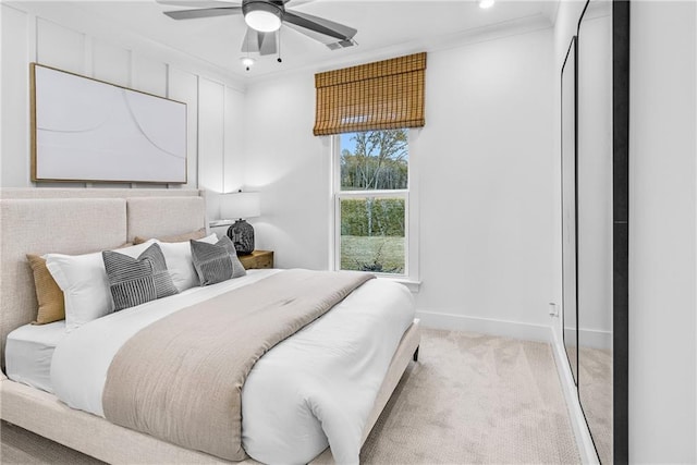 bedroom with ceiling fan, crown molding, and light colored carpet