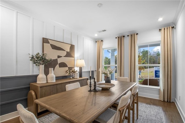 dining area featuring dark hardwood / wood-style flooring and crown molding