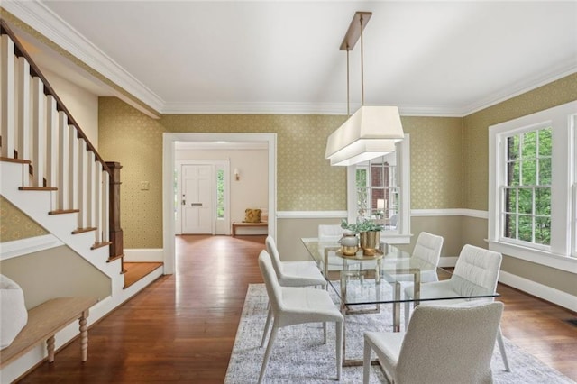 dining area with wood finished floors, stairway, ornamental molding, baseboards, and wallpapered walls