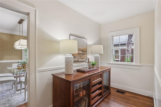 home office with wainscoting, crown molding, and wood finished floors
