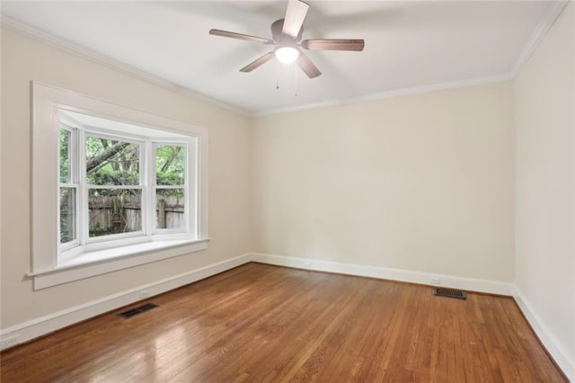 empty room with wood finished floors, baseboards, ornamental molding, and a ceiling fan