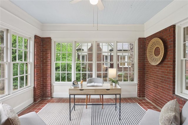 sunroom / solarium with healthy amount of natural light, baseboards, brick wall, and tile patterned floors