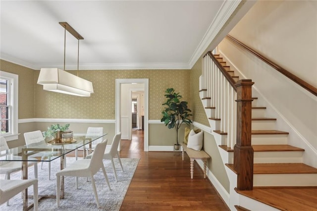 dining area with stairway, wood finished floors, ornamental molding, and wallpapered walls
