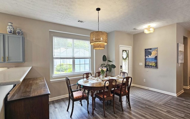 dining space featuring a chandelier, baseboards, visible vents, a textured ceiling, and dark wood-type flooring