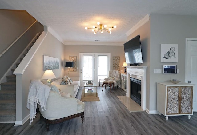 living room with wood finished floors, crown molding, a chandelier, and stairs