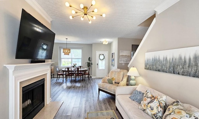 living room featuring an inviting chandelier, a fireplace, baseboards, a textured ceiling, and wood finished floors