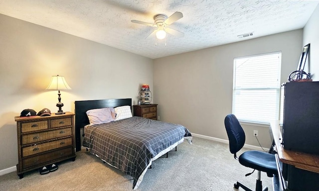 bedroom featuring a textured ceiling, visible vents, baseboards, and light carpet