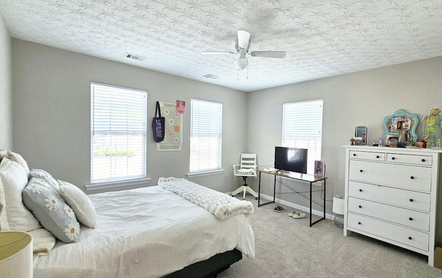 carpeted bedroom with a ceiling fan, visible vents, and baseboards
