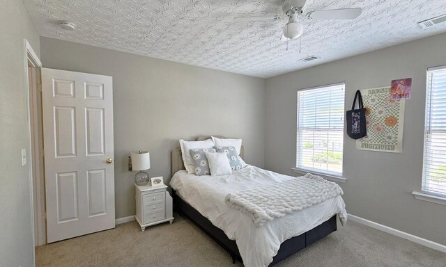 bedroom featuring baseboards, visible vents, and light carpet