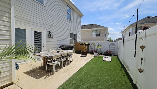 back of property featuring a patio, a yard, and a fenced backyard