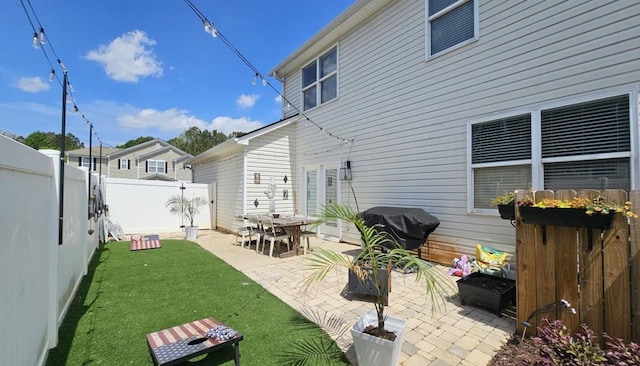 back of house featuring a yard, a fenced backyard, and a patio area