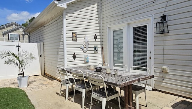 view of patio / terrace featuring a gate, fence, and outdoor dining area