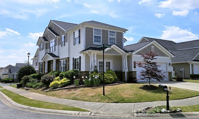 view of front facade featuring stone siding, a front yard, concrete driveway, and an attached garage