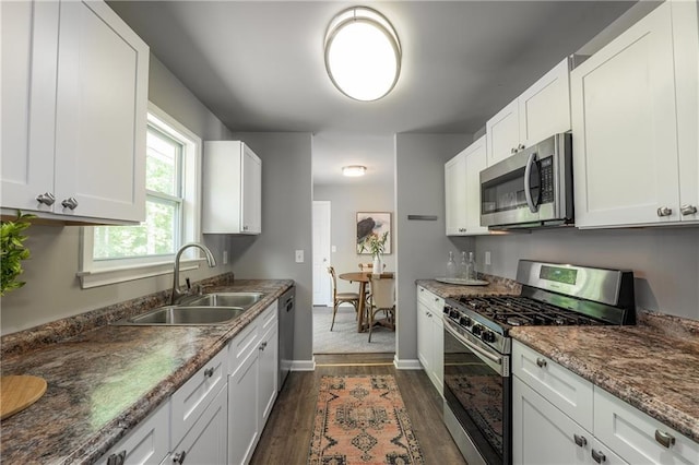 4408 Brandon Ct NE, Marietta, GA 30066 - kitchen featuring appliances with stainless steel finishes, a sink, dark wood-style floors, baseboards, and white cabinets