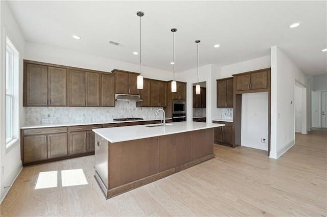 784 Keystone Dr, Woodstock, GA 30188 - kitchen featuring a sink, decorative backsplash, stainless steel appliances, light wood-style flooring, and a spacious island