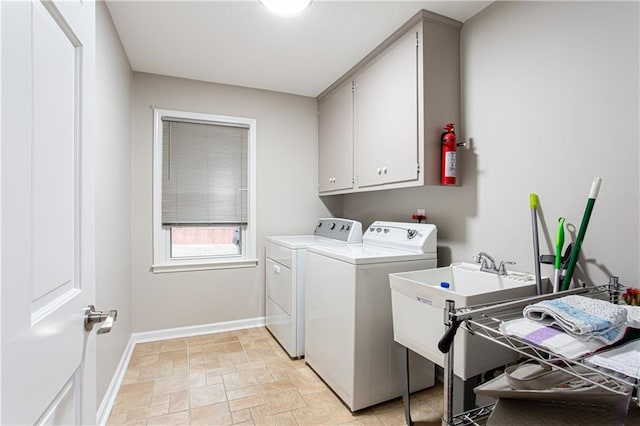 clothes washing area with cabinets and washing machine and clothes dryer