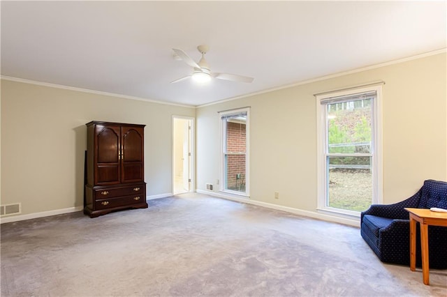 living area with crown molding, light carpet, and ceiling fan