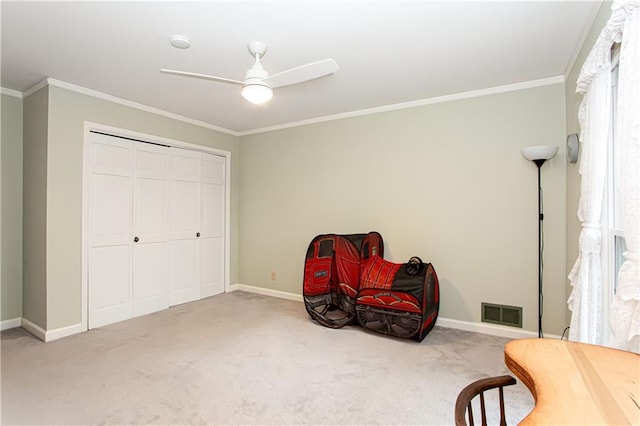 sitting room featuring ornamental molding, carpet flooring, and ceiling fan