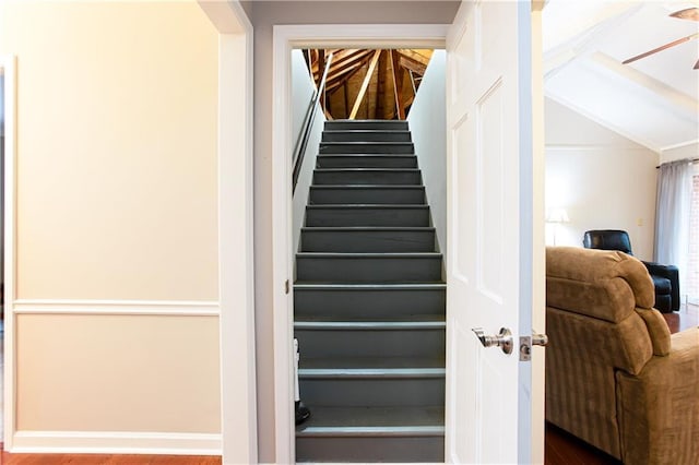 stairs featuring hardwood / wood-style flooring and lofted ceiling