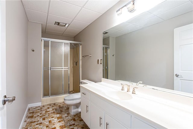 bathroom with walk in shower, a paneled ceiling, vanity, and toilet