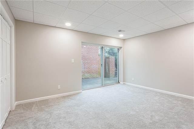 empty room featuring carpet flooring and a drop ceiling