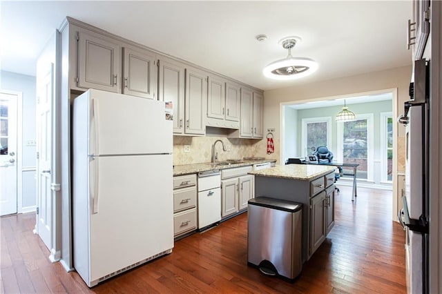 kitchen featuring white fridge, a center island, sink, and dark hardwood / wood-style flooring