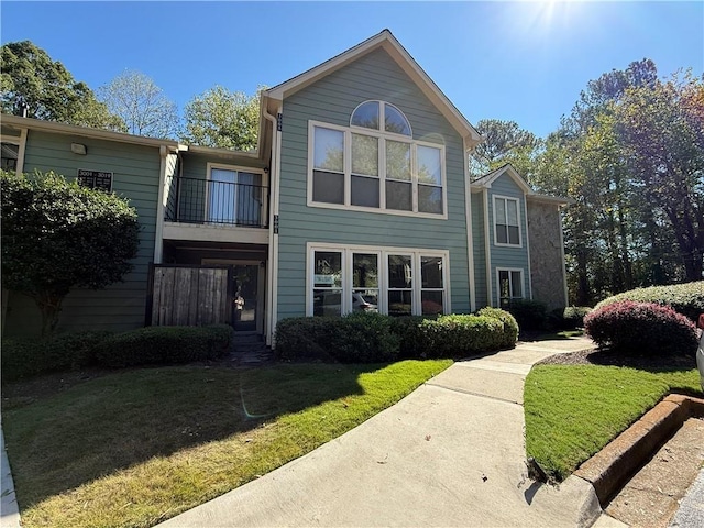 view of front facade featuring a balcony and a front yard