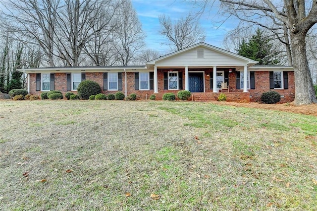 ranch-style home featuring a front lawn and covered porch