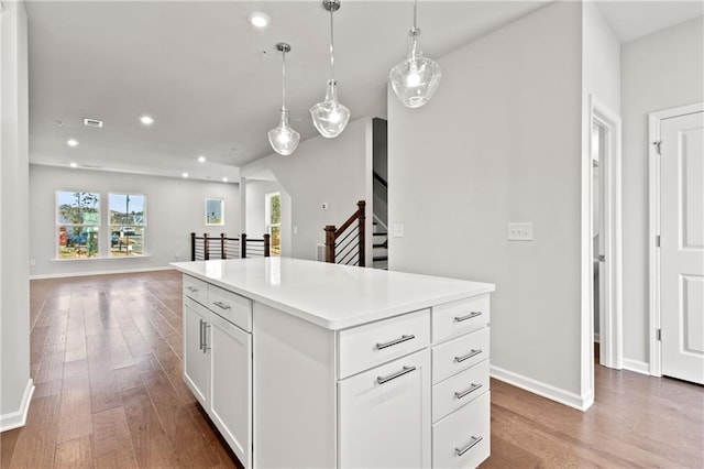 kitchen featuring white cabinetry, a center island, hardwood / wood-style floors, and hanging light fixtures